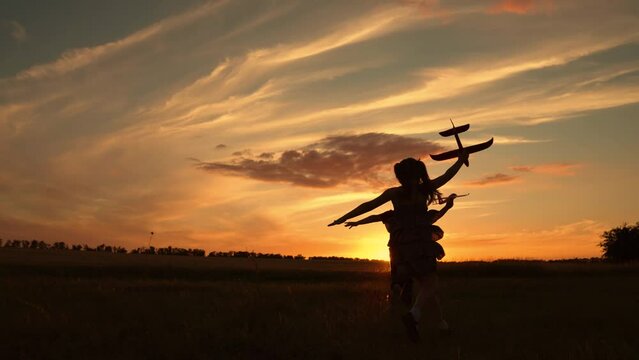 Children boy girl play with toy plane. Child aviator running with toy plane across field against sky. Child wants to become an astronaut. Teenage dreams of flying, becoming pilot. Freedom concept