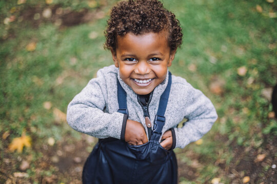 Portrait Of Happy Boy Standing In Park