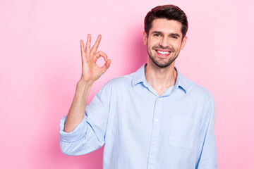 Fototapeta premium Photo of positive glad man wear stylish clothes arm demonstrate okey symbol done finish task empty space isolated on pink color background