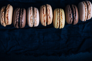 Macaroons on dark background, pastel french cookies macaroons