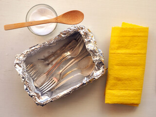 Aluminum foil, white vinegar, baking soda for clean silver. Life hacks concept.