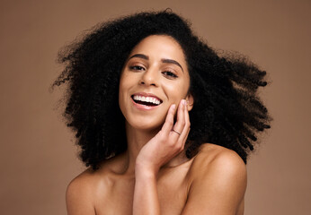 Woman, studio portrait and afro with beauty, makeup and cosmetic wellness with hands, face or natural hair. Model, skincare and facial cosmetics, self care glow and smile by brown studio background