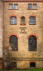 Fototapeta na wymiar Fassade des Hauptgebäudes der denkmalgeschützten Papierfabrik in Spechthausen mit dem Firmenwappen und der Jahreszahl 1903