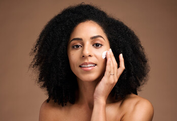 Face, cream and black woman in studio for skincare, beauty and cosmetics promotion with product...