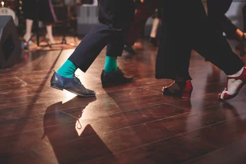 Foto op Plexiglas Dancing shoes of young couple dance retro jazz swing dances on a ballroom club wooden floor, close up view of shoes, female and male, dance lessons class rehearsal © tsuguliev