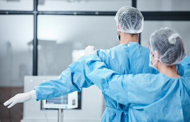 Doctor, uniform and surgeon prepare for surgery, operation or medical healthcare. Nurse helping...