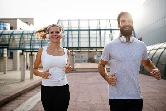 Fitness sport friendship people and lifestyle concept. Happy fit smiling couple running outdoors