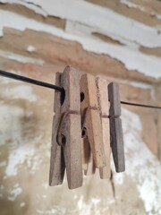 clothespin hangs on a rope against the background of an old wall