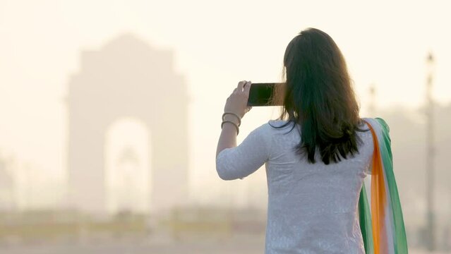 Indian girl taking pictures at India gate