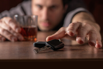 Do not drink and drive. Drunk man with glass alcohol in hand taking car keys