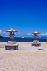 Fototapeta premium 広い海岸に立つ青島神社の石灯籠（宮崎県宮崎市）