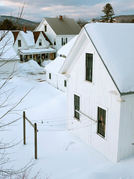 Snow-covered, pitched roofs and empty backyard clotheslines epitomize small New England community in Kingfield, Maine in the winter season.