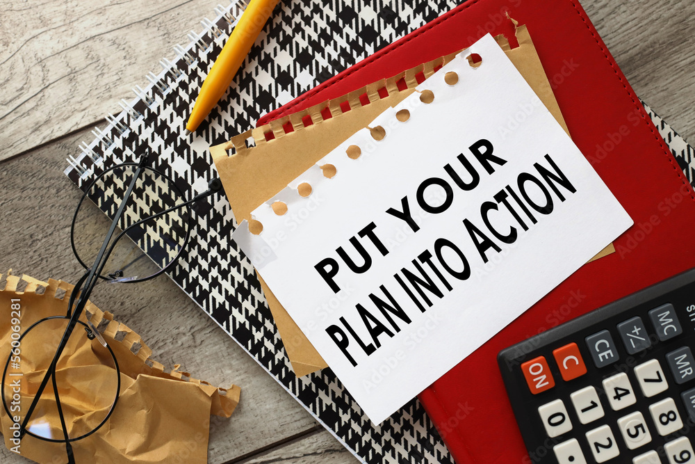 Poster put your plan into action words in a notepad next to the calculator.