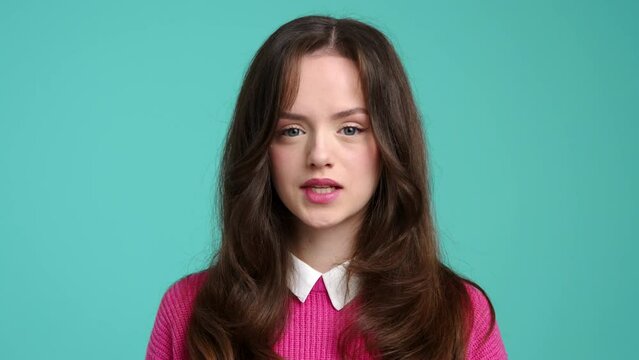 Close-up of a serious caucasian woman looking beautiful inside a colorful room. Portrait of a cute female teenager biting her lip. High quality 4k footage