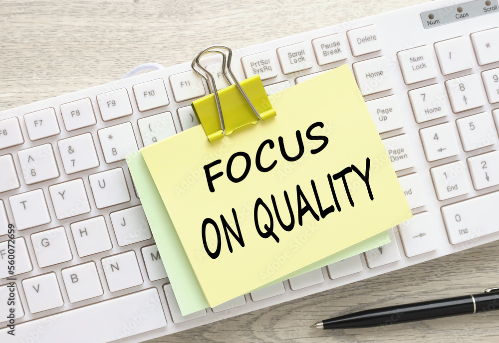 Poster focus on quality symbol. sticker with text on white keyboard. on the work table. copy space.