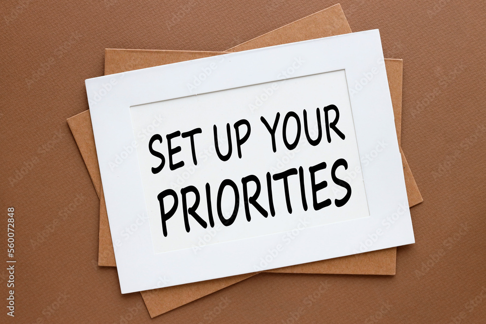 Poster set up your priorities symbol. three frames are thrown on a brown background. text in a white frame.