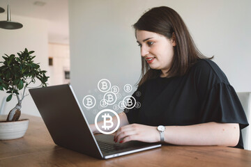 Fototapeta na wymiar Bitcoin sign over the photo in front of a woman working on her laptop in the office