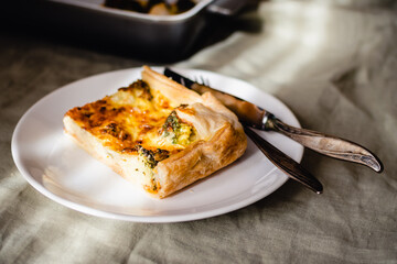 Sliced traditional french open quiche pie with cheese and broccoli