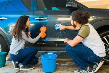 Hispanic couple washing their car