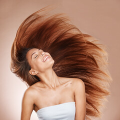 Hair care, wellness and woman in studio with salon, keratin or botox health hair treatment. Cosmetics, happy and female model from Brazil with a long, healthy and brown hair style by brown background