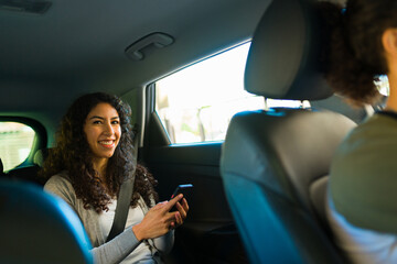Happy passenger using the rideshare mobile app - obrazy, fototapety, plakaty