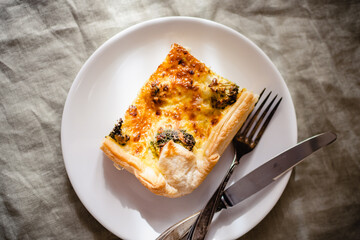 Sliced traditional french open quiche pie with cheese and broccoli