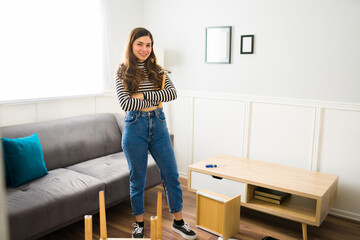 Cheerful woman using tools to assembly furniture