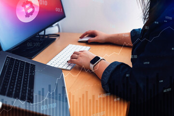 Unrecognizable woman working with a computer and laptop, typing on key board, wearing a smart watch