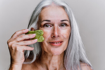 Image of a beautiful senior woman posing on a beauty photo session. Middle aged woman on a colored...