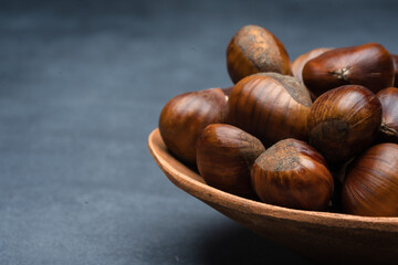 Raw roasted chestnuts on black background	

