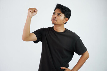 asian man show fist up feels positive or happy with successful wearing black t shirt, Man satisfied happy about victory isolated on white background