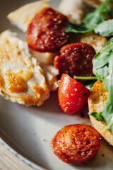 Fried chicken fillet and fresh vegetable salad of tomatoes and arugula leaves.