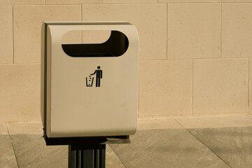 Do Not Throw Rubbish sign on a modern minimalist garbage container on empty wall background, ecology care and clean street concept