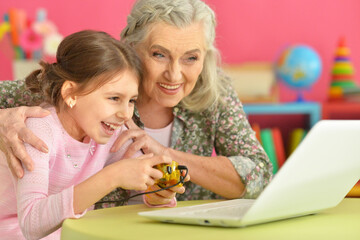 granny with her granddaughter playing computer game