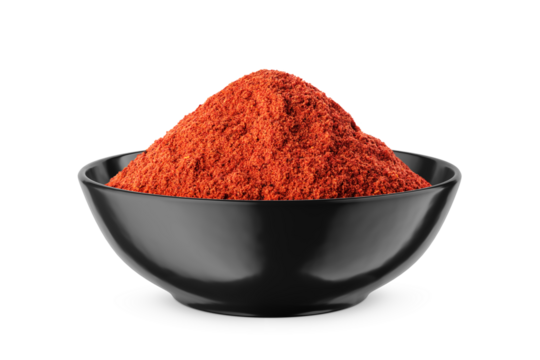 Ground red pepper in black bowl isolated on white. Front view.
