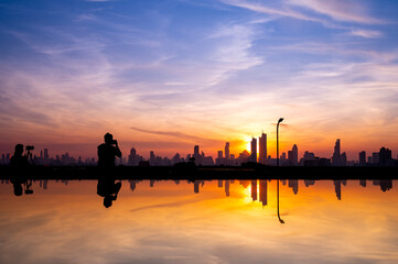 cityscape of Bangkok city skyline silhouette and reflextion  on glass top table with sunset sky background, Bangkok city is modern metropolis of Thailand and favorite of tourists
