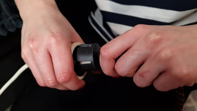 Woman plugging black plug in extension cord socket. Electricity, connection, energy supply and consumption concept