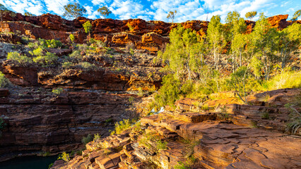 Sunrise over dales gorge in karijini national park, western australia; Australian outback with red rocks, distinctive trees and mountains in the background