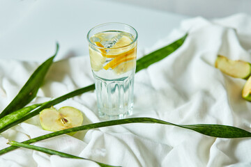 Fresh cool lemon infused water, cocktail, detox drink, lemonade in a glass with metal eco cocktail tube, nutrition diet concept