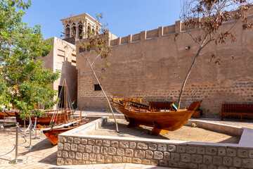 Small traditional wooden rowing boats - abras , with Al Fahidi Old Fort walls in the background, Al...