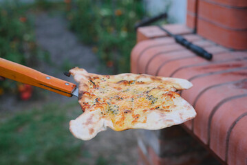 Cooking pizza in ove. Сook takes cooked focaccia out of oven using shovel