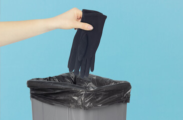 throw gloves in the trash can, gloves in hand in front of the trash can, fabric recycling