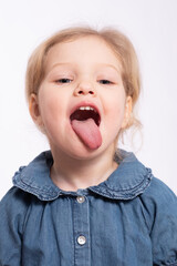 Pretty little girl opened her mouth and shows tongue