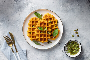 Pumpkin gluten free breakfast waffles on white plate. Vegetarian food concept. top view