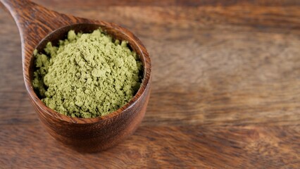 Matcha tea powder in wooden spoon. Healthy drinks concept
