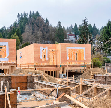Wooden frame of new house with concrete filled fundation in front