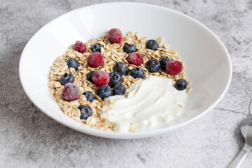 Oatmeal flaking with fresh blueberries, on a concrete background. healthy eating