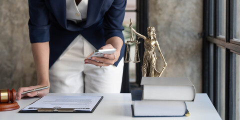 Attractive young lawyer or Businesswoman talking on phone and lawyers discussing contract papers...