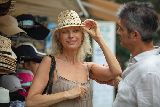 woman trying a hat in a hat store - Powered by Adobe