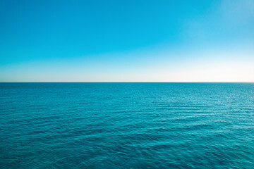 Naklejka na ściany i meble Summer seascape. Cruise on the ship. Blue sea, sky and horizon line.
